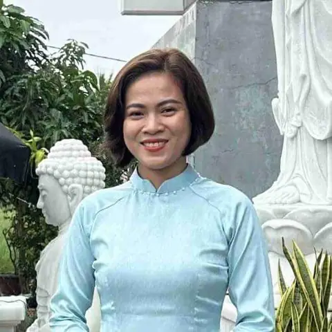 Một Người Phụ Nữ Mặc Váy Xanh Đứng Trước Bức Tượng.