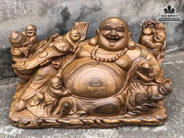 Từ Xưa, Tượng Phật Di Lặc Hay Còn Được Gọi Là Tượng Thần Tài, Tượng Ông Phỗng, Ông Bụng Phệ Luôn Là Sự Lựa Chọn Được Nhiều Tay Chơi Lão Luyện Trong Giới Phong Thủy Ưa Chuộng Và Ngày Càng Trở Nên Quen Thuộc Với Cuộc Sống Của Mọi Người Dân Việt Nam Nói Riêng Và Thế Giới Nói Chung. Ngoài Ý Nghĩa Tâm Linh, Tượng Phật Di Lặc Bằng Gỗ Còn Có Giá Trị Rất Lớn Trong Văn Hoá Tinh Thần Và Vật Chất. Trong Các Mẫu Tượng Gỗ Di Lặc Đẹp Hiện Nay Thì Tượng Di Lặc Ngũ Phúc Đang Là Sự Lựa Chọn Của Đông Đảo Tín Đồ Phong Thủy, Nội Thất. Vì Sao Lại Như Thế Thì Mọi Người Hãy Cùng Gỗ Đỉnh Tìm Hiểu Nhé.